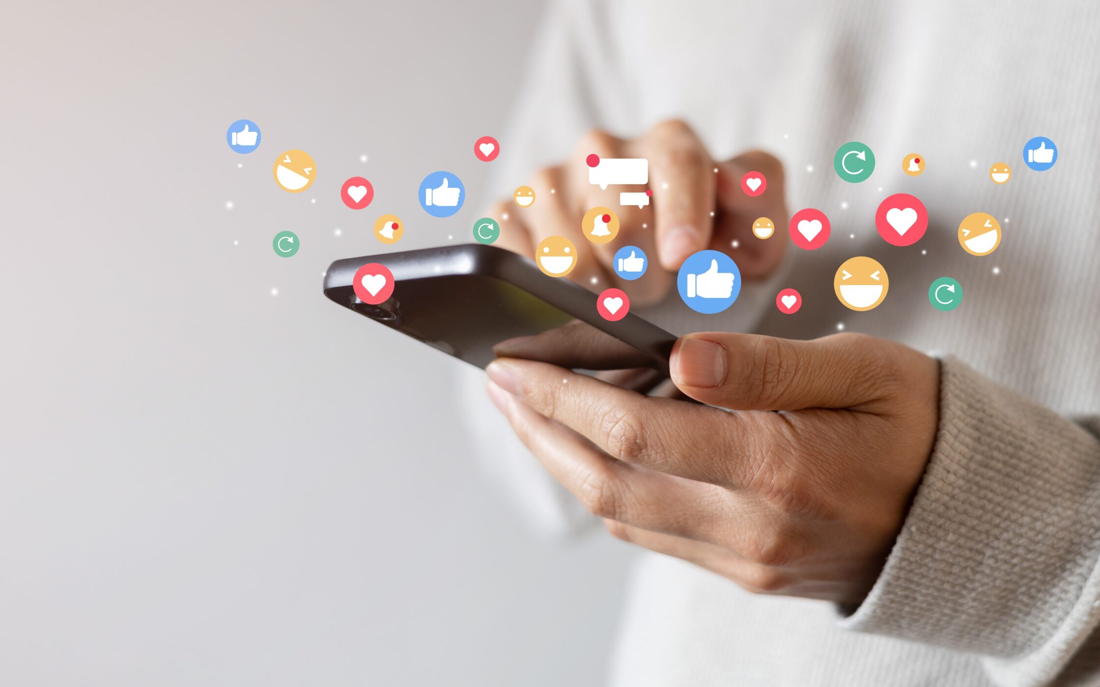 A man holding a smartphone and using social media for new interactions such as likes, comments, and shares - everything that can improve social media post optimization.